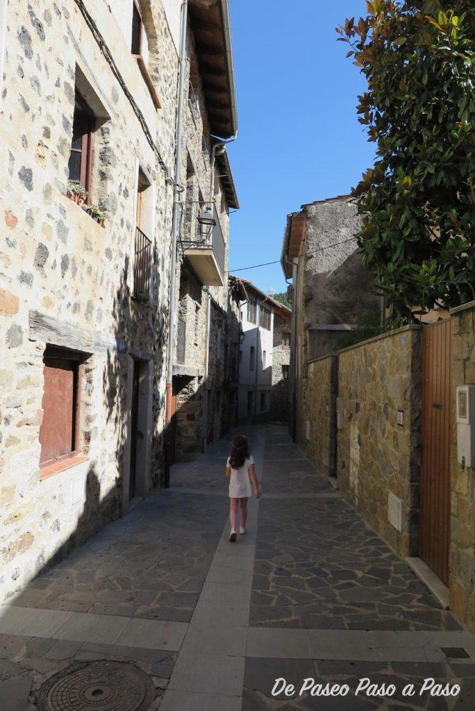 Niña caminando por calle del pueblo Castelfollit de la roca