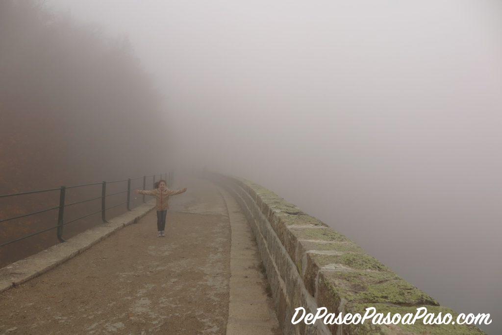 Niña en medio de la presa del pantano Santa Fe de Montseny, tapada por la niebla