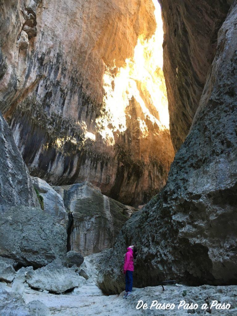 niña mirando hacia arriba entre las paredes del nacimiento rio matarraña