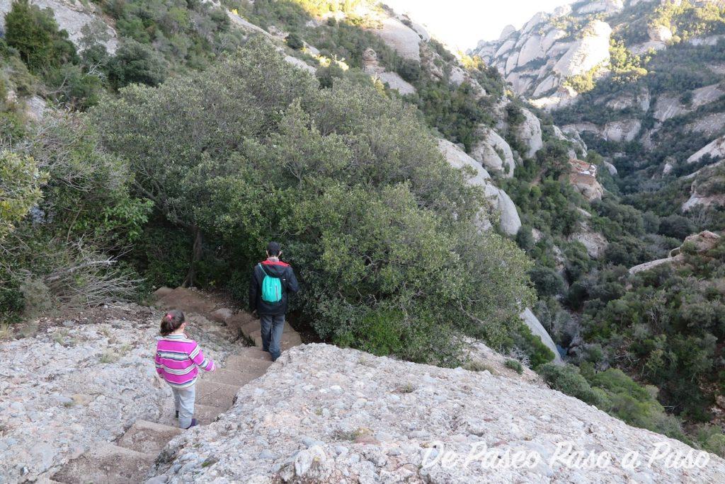 Padre e hija bajando la montaña por escaleras en la roca