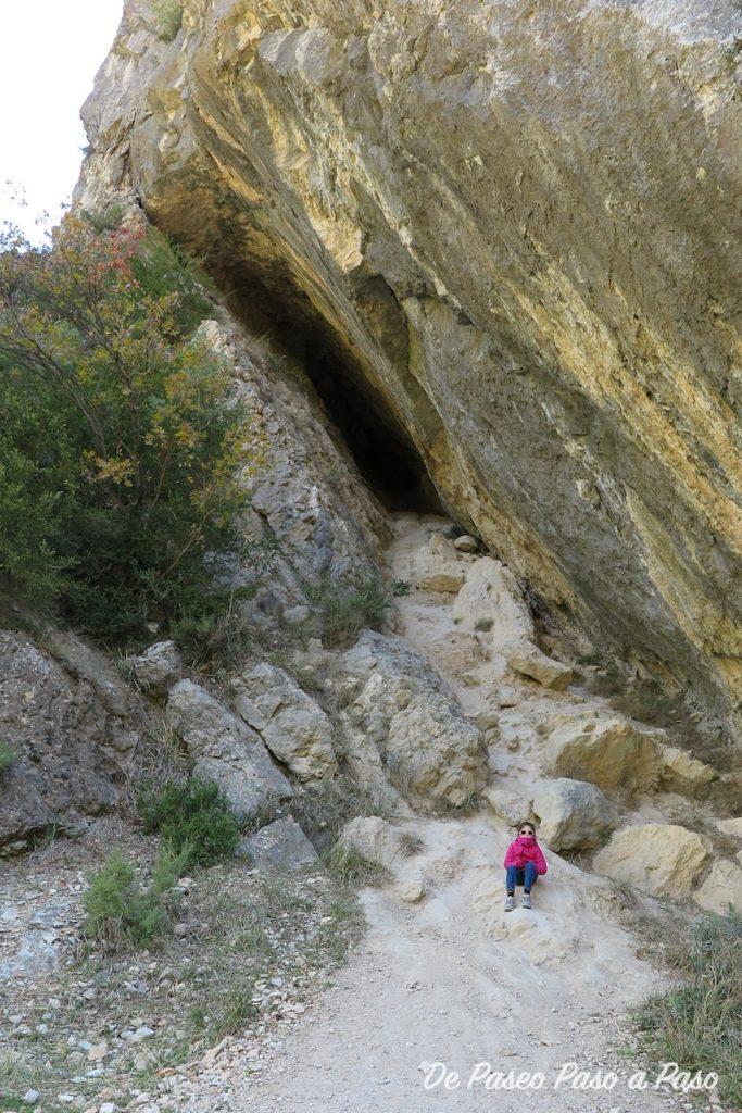 Niña en la entrada de una cueva