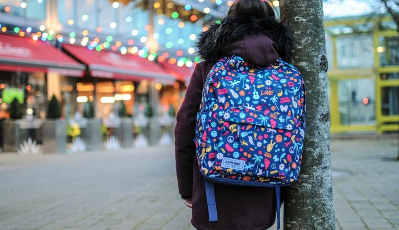 niña con mochila de espalda en parque temático