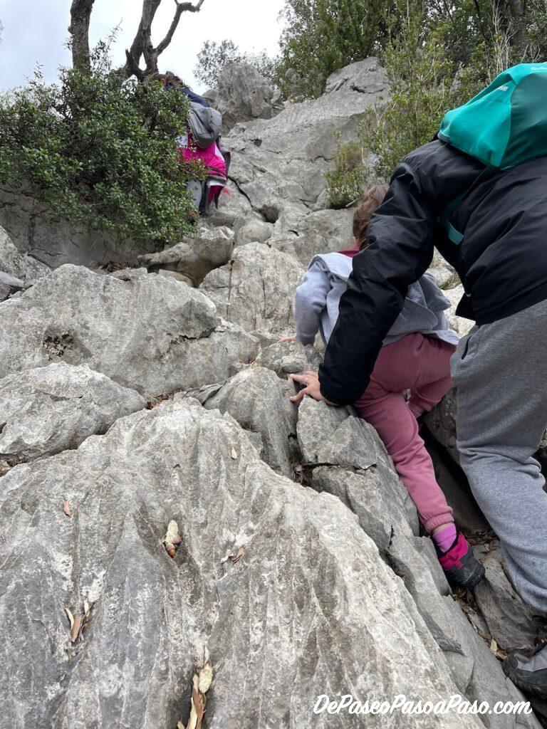 Trepada en la roca camino a la Cova del Bisbe